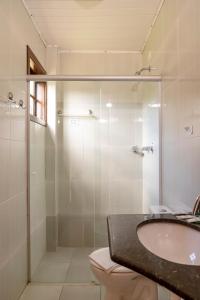 une salle de bain avec douche, lavabo et toilettes dans l'établissement Pousada Portal da Serra, à Campos do Jordão