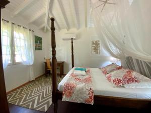 a bedroom with a bed with a canopy at Villa Cézanne in Sainte-Rose +27 photos
