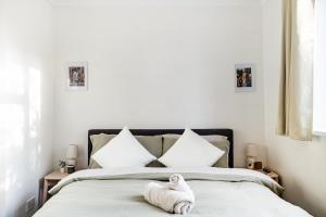 Ein ausgestopftes Tier sitzt auf einem Bett in der Unterkunft Cosy 2-Bed Maisonette in Ashford in Kennington