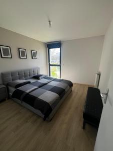 ein Schlafzimmer mit einem Bett und einem großen Fenster in der Unterkunft Quiet and Spacious 2BR And Salon Terrasse Parking in Saint-Denis