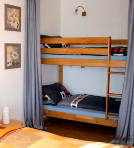 シャイデックにあるFerienwohnung Allgäu-Harmonie - Pool, Sauna, Bergblick, 2 Zimmerのベッドルーム1室(青いカーテン付きの二段ベッド2組付)