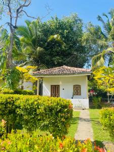 a small white house with trees and bushes at Cabana Unawatuna in Unawatuna