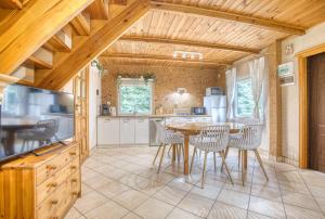 een keuken met een tafel en stoelen in een kamer bij Domki Letniskowe Jerutki in Świętajno