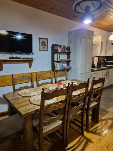 a dining room with a wooden table and chairs at Hereczówka in Laskówka