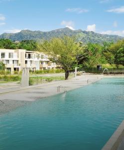 a pool of blue water in front of a building at KOA Villeta - Loft y terraza con vista a la montaña in Nimaima
