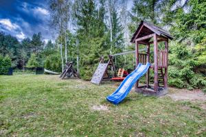 een speeltuin met een glijbaan en een speelstructuur bij Domki Letniskowe Jerutki in Świętajno