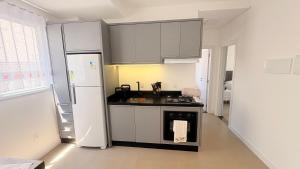 a kitchen with a stove and a refrigerator at palmas beach in Governador Celso Ramos