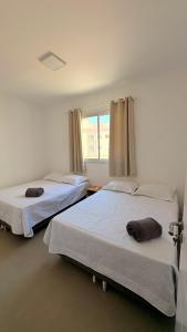 two beds in a room with a window at palmas beach in Governador Celso Ramos +15 photos