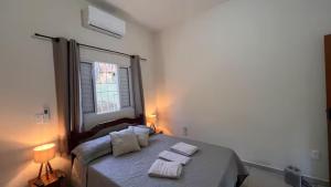 une chambre avec un lit avec deux serviettes dessus dans l'établissement Suíte Refúgio da Natureza - Cozinha - Self checkin - Suite 2, à Torrinha