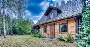 een blokhut in het bos met een tuin bij Domki Letniskowe Jerutki in Świętajno