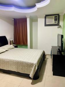 a bedroom with a bed and a television in it at Comfortable apartment, excellent location in Maracaibo