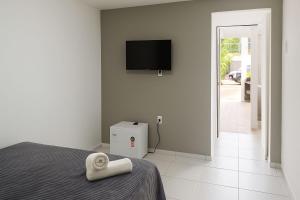 a bedroom with a bed with a towel on it at Pousada Jardins in São Luís