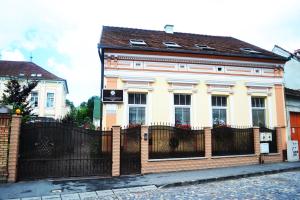 a house with a fence in front of it at Pensiunea Lucia in Sfântu-Gheorghe