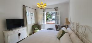 a bedroom with a large bed and a television at Villa Vicuña Salta Hotel Boutique in Salta