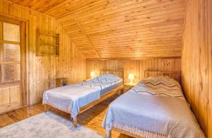 een slaapkamer met 2 bedden in een houten hut bij Domki Letniskowe Jerutki in Świętajno