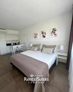 a bedroom with a large white bed and a kitchen at RENTAL SUITES CAMPANA in Campana +23 photos