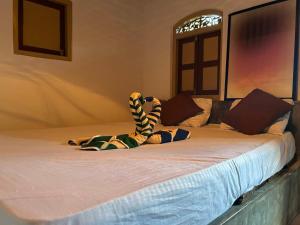a stuffed animal is laying on a bed at Cabana Unawatuna in Unawatuna
