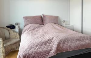 1 cama con edredón rosa y silla en 1 Bedroom Cozy Apartment In Aarhus C, en Århus Østbanegård