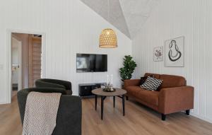 a living room with a couch and a table at Awesome Home In Glesborg With Sauna in Fjellerup