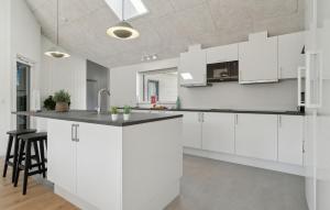 a white kitchen with white cabinets and a counter at Awesome Home In Glesborg With Sauna in Fjellerup