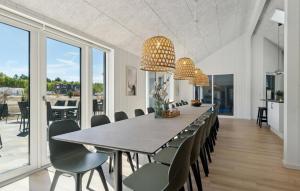 a dining room with a long table and chairs at Awesome Home In Glesborg With Sauna in Fjellerup