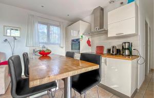 kuchnia z drewnianym stołem i czarnymi krzesłami w obiekcie Cozy Home In Roquebrune-Sur-Argens With Outdoor Swimming Pool w mieście La Rouviere