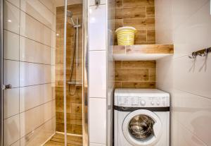 een kleine badkamer met een wasmachine en een douche bij Domki Letniskowe Jerutki in Świętajno +43 foto's