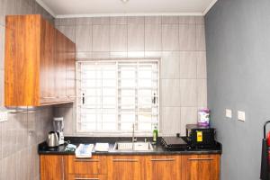 eine Küche mit Spüle und Fenster in der Unterkunft 2Bedroom Apartment at Pokuase in Ayaso