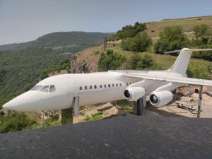 a white airplane sitting on top of a mountain at Lostin clouds in Yenokavan