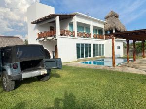 ein schwarzer Jeep, der vor einem Haus geparkt ist in der Unterkunft Beautiful Beach House in Barra de Coyuca