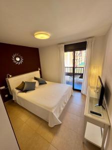 a bedroom with a bed and a desk and a television at Sil&Sol in Arona