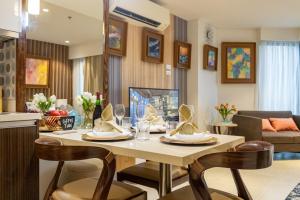 Un comedor y una sala de estar con mesa y sillas. en Kate & Keith's Place - Tambuli Seaside Living, en Lapu Lapu City