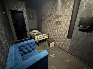 Habitación con sofá azul y cama en Hostel, en Ereván