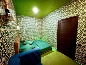 1 dormitorio con paredes verdes, 1 cama y puerta en Hostel, en Ereván