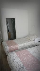 Dos camas una al lado de la otra en una habitación. en La mesa del cocinero, en Lugo