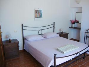 CampagnaticoにあるAgriturismo Podere Selvetteのベッドルーム1室(白いベッド1台、ナイトスタンド2台付)