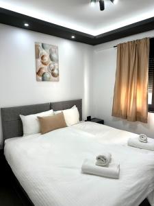 a bedroom with a large white bed with towels on it at Prenoćište Vozač in Jajce