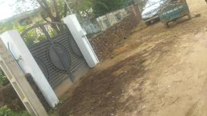 a gate on a dirt road with a bench at Maison Popenguine sur Mer in Poponguine