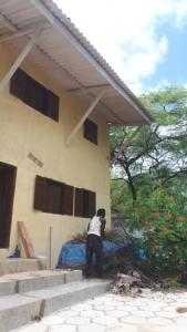 a person standing in front of a house at Maison Popenguine sur Mer in Poponguine