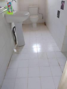 a white bathroom with a sink and a toilet at Maison Popenguine sur Mer in Poponguine