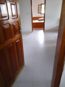 a room with a door and a white tile floor at Maison Popenguine sur Mer in Poponguine