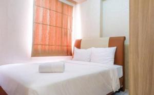 a bedroom with a white bed with a window at Menteng Square Sahara II in Jakarta