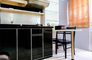 a kitchen with a black counter and a table at Menteng Square Sahara II in Jakarta