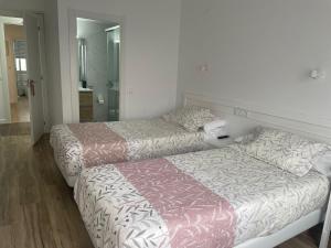 a bedroom with two beds and a mirror at La mesa del cocinero in Lugo