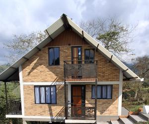 a house with a balcony on the side of it at Cabaña privada cerca de Armenia Quiet Mountain View Country Home in Salento