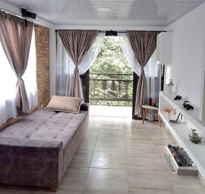 a bedroom with a large bed and a large window at Cabaña privada cerca de Armenia Quiet Mountain View Country Home in Salento