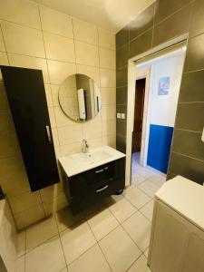 ein Badezimmer mit Waschbecken und Spiegel in der Unterkunft Le Siesskass in Gunsbach