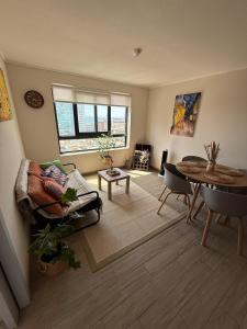 ein Wohnzimmer mit Sofa und Tisch in der Unterkunft Acogedor Departamento en pleno centro de Antofagasta, hasta 4 personas, 1D 1B 1 sofá cama in Antofagasta