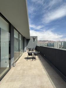 ein Balkon mit Tisch und Stühlen auf einem Gebäude in der Unterkunft Acogedor Departamento en pleno centro de Antofagasta, hasta 4 personas, 1D 1B 1 sofá cama in Antofagasta