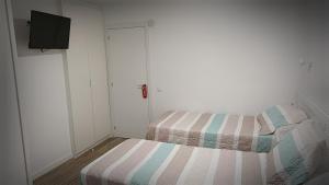 Habitación pequeña con 2 camas y TV. en La mesa del cocinero, en Lugo 3 fotos más
